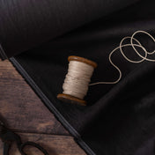 Bobbin on black linen fabric