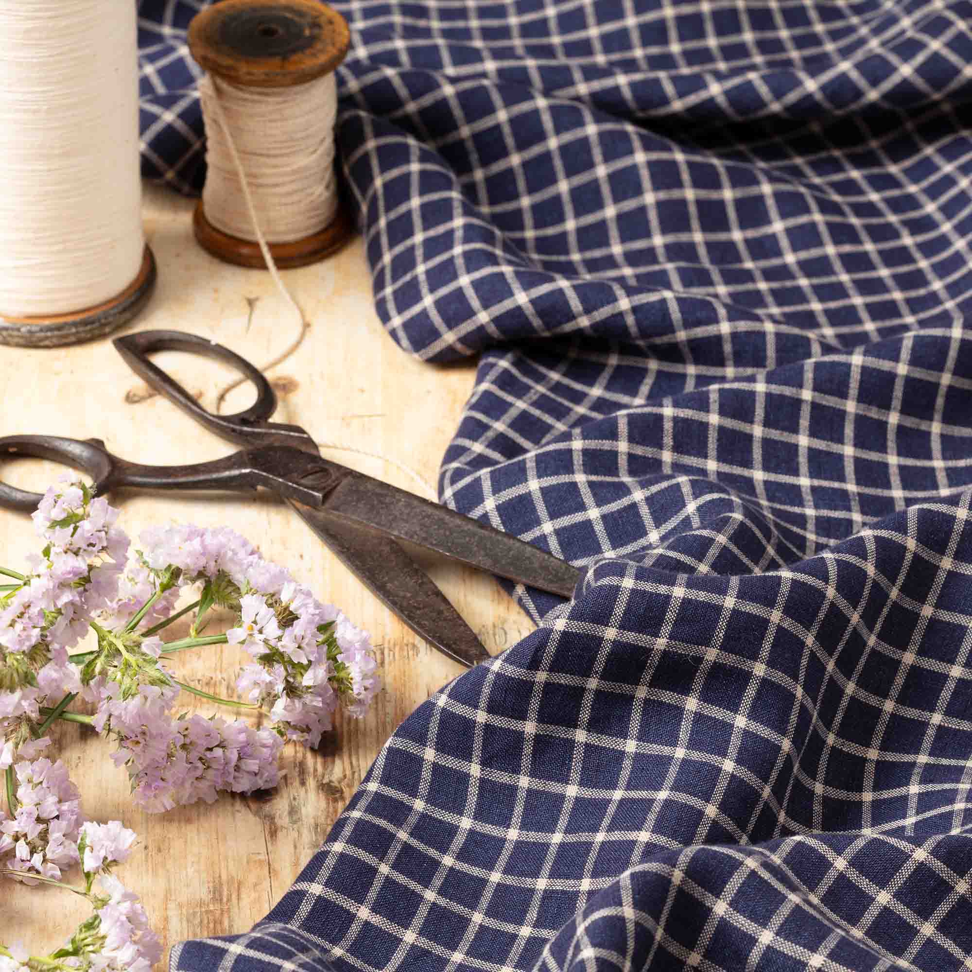 Navy Check linen fabric, ready to cut, with scissors, thread bobbins and flowers