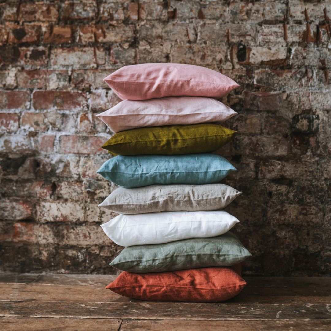 colourful washed linen piled up on wooden floor
