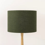 Dark green lampshade made from textured linen on wooden stand