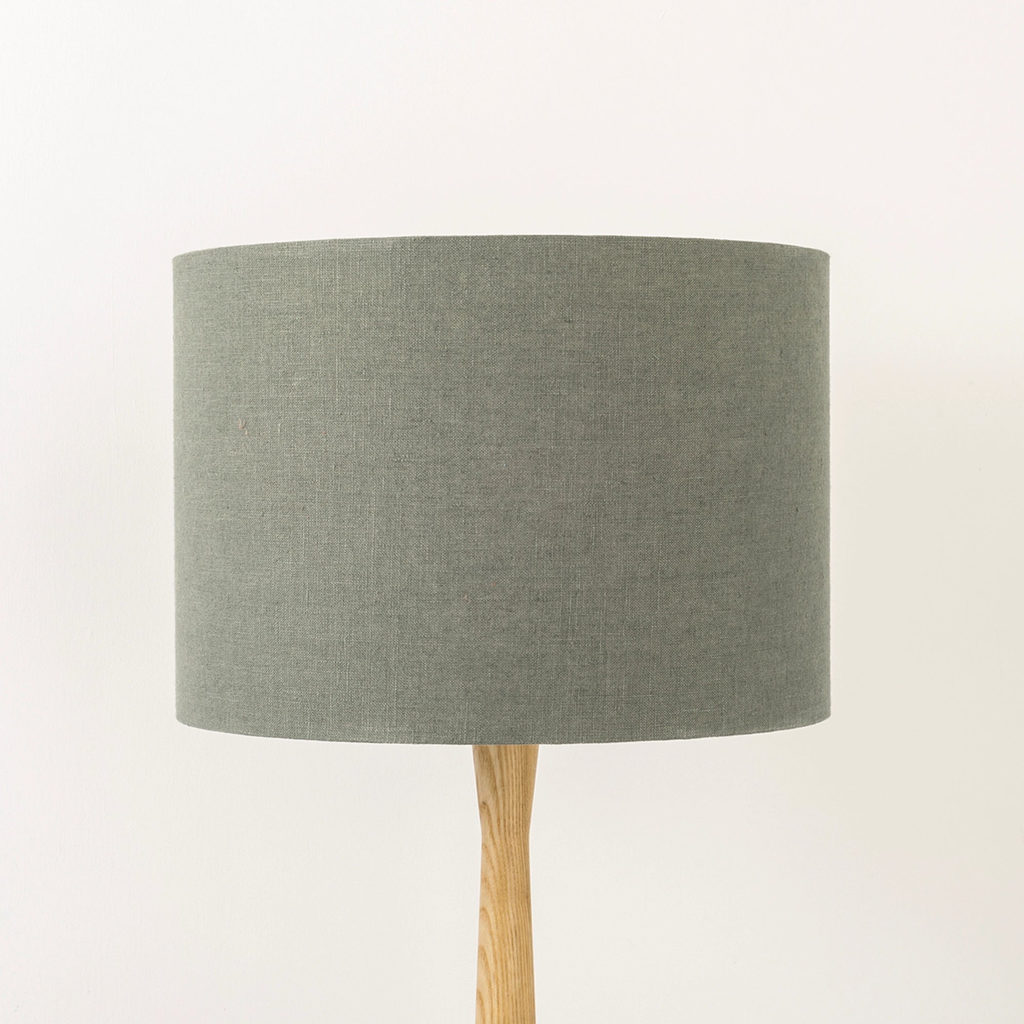 Dusty sage lampshade made from textured linen on wooden stand