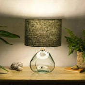 Dusty sage lampshade made from textured linen illuminated on recycled glass table lamp