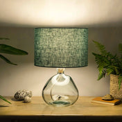 Dusty turquoise lampshade made from textured linen illuminated on recycled glass table lamp