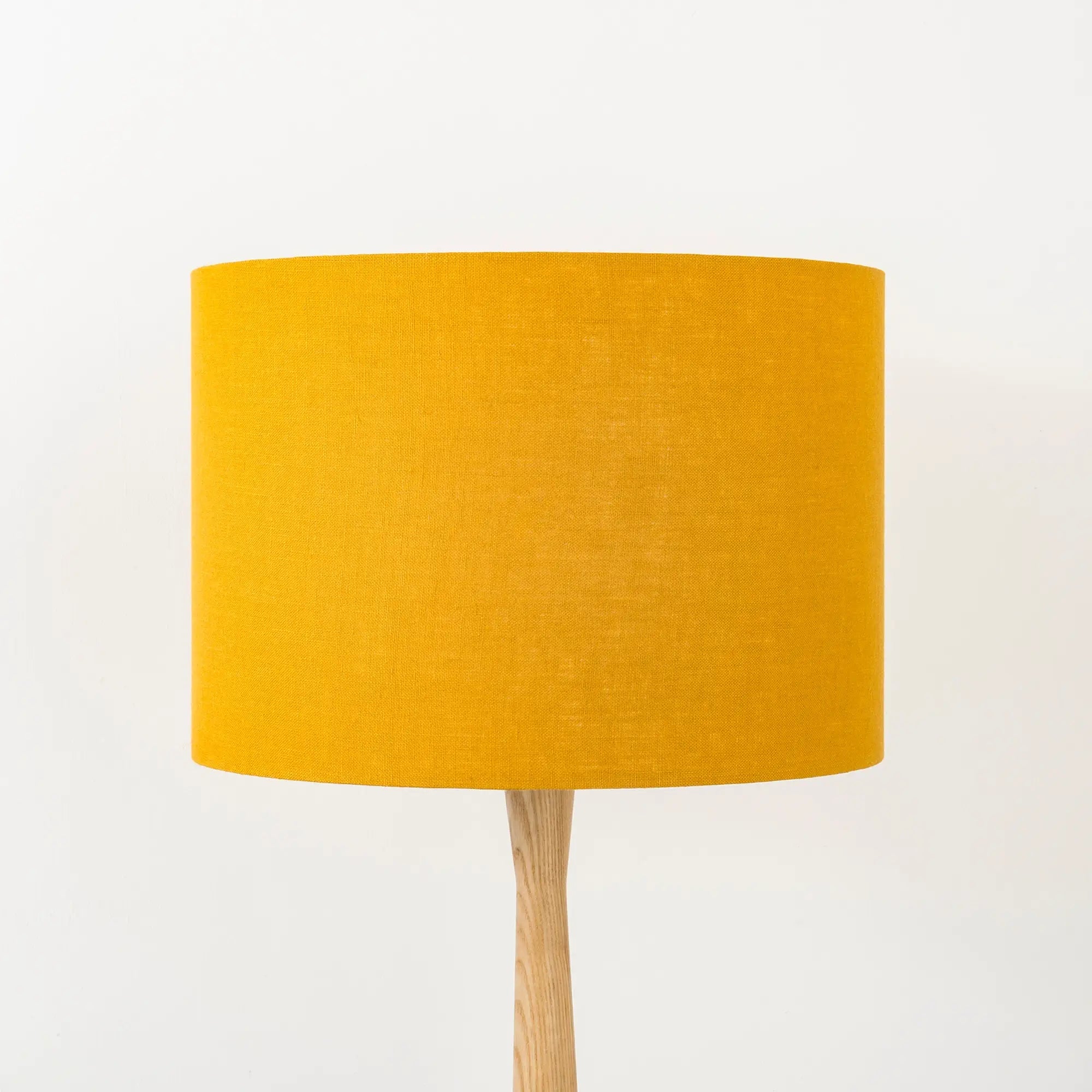 Mustard yellow lampshade made from textured linen on wooden stand