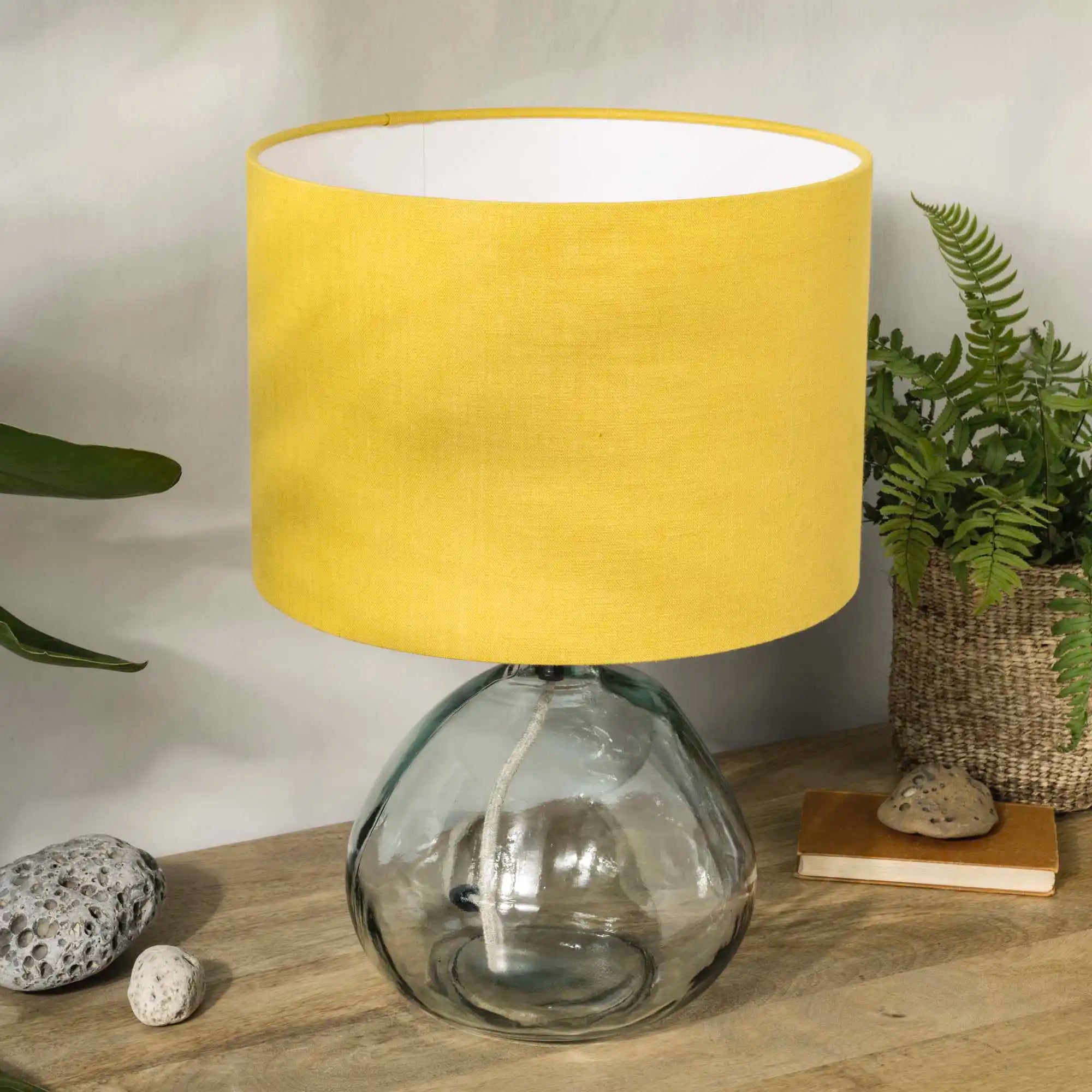 Honey yellow linen lampshade on recycled glass base with house plants