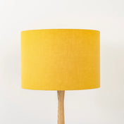 Honey yellow lampshade made from textured linen on wooden stand