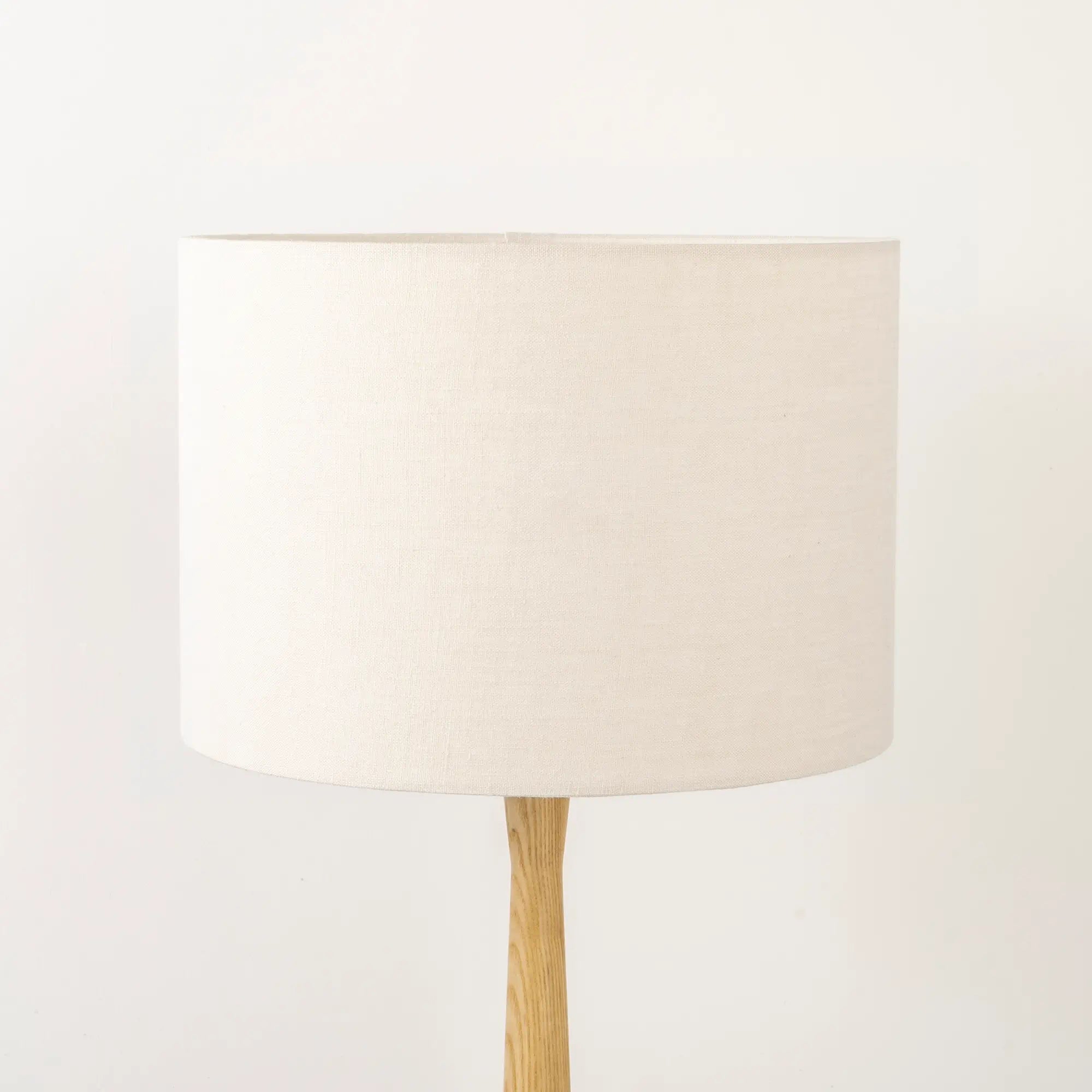 White lampshade made from textured linen on wooden stand