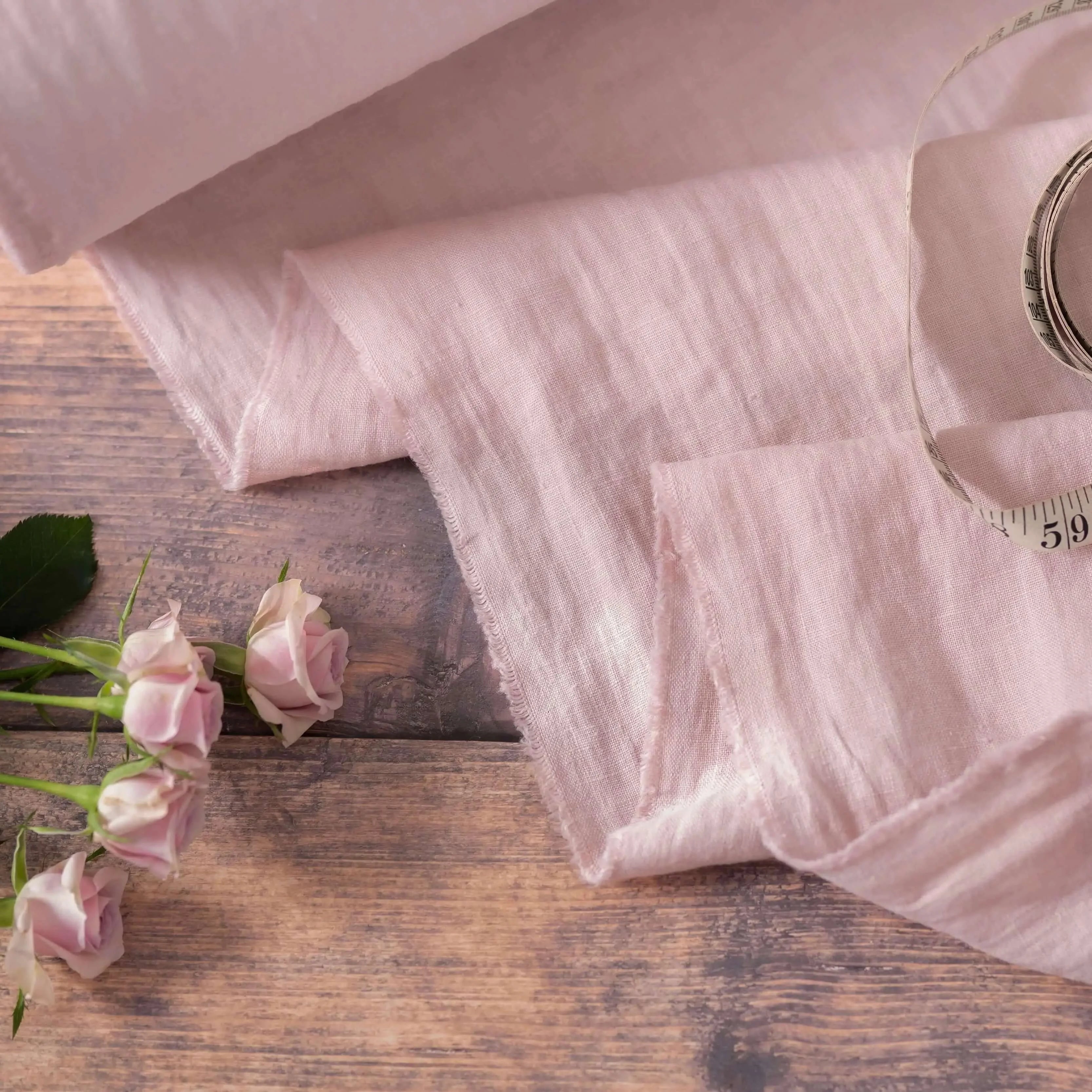 Light Dusty Pink linen fabric, ready to cut, with measuring tape and flowers