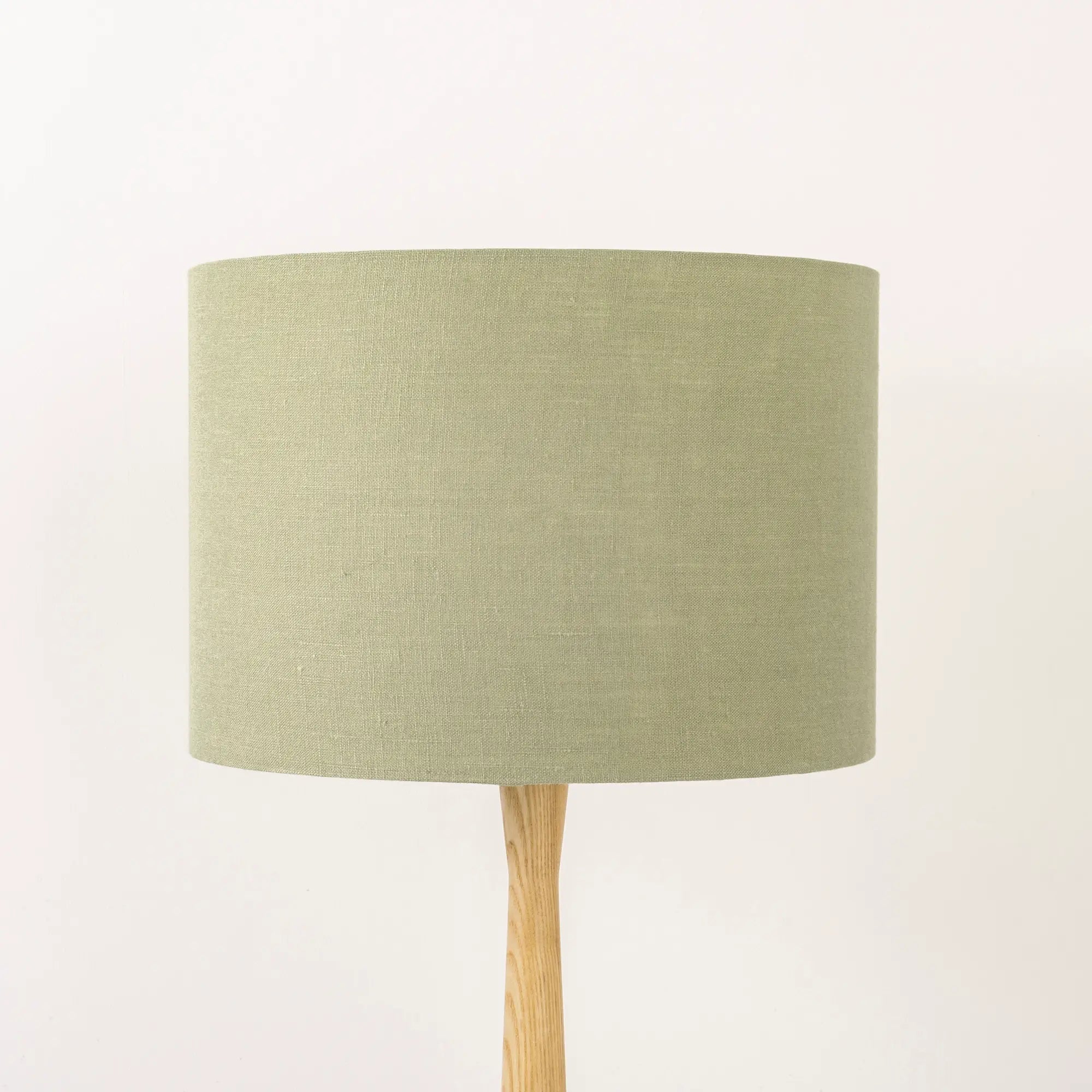 Light sage lampshade made from textured linen on wooden stand