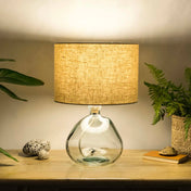 Oatmeal lampshade made from textured linen illuminated on recycled glass table lamp