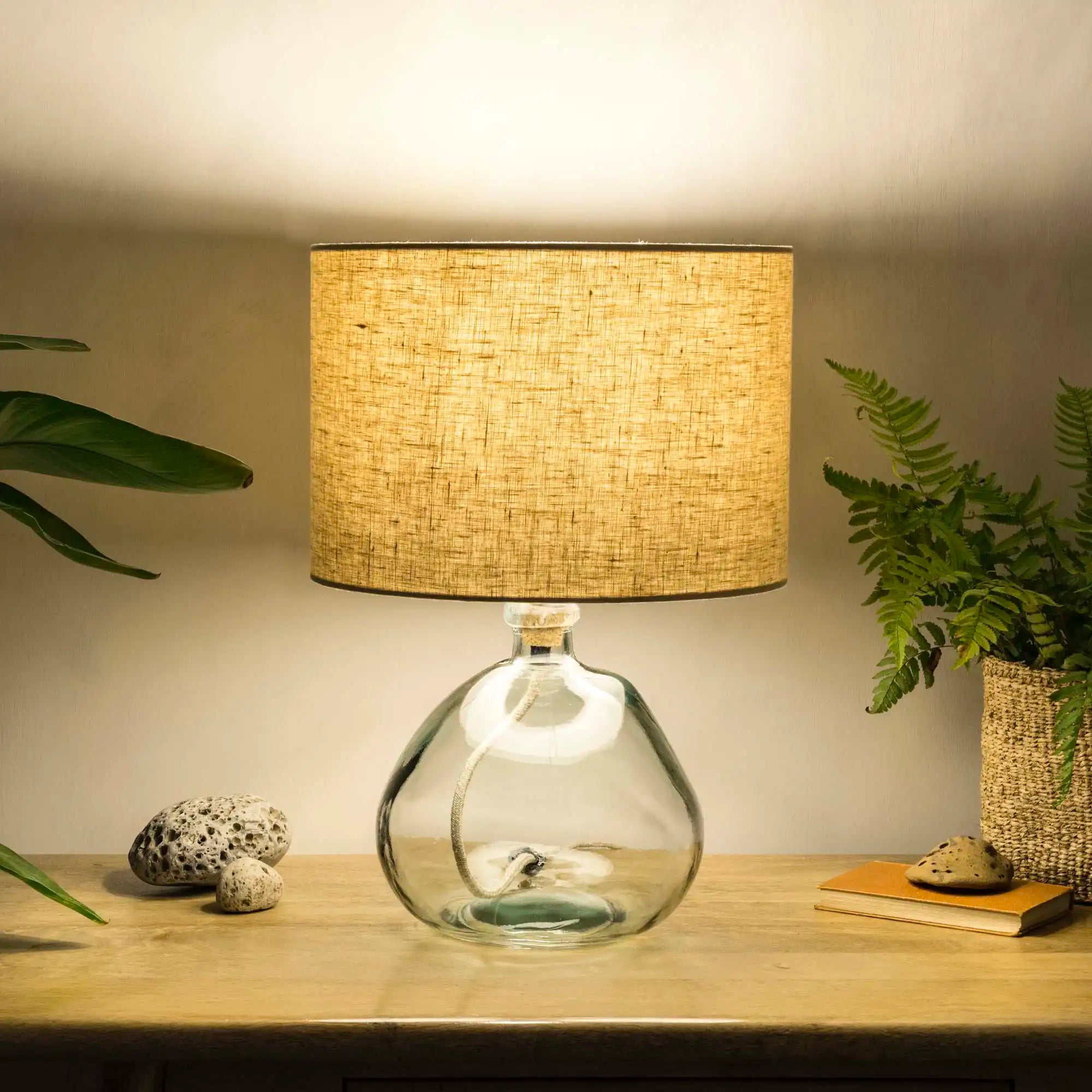 Oatmeal lampshade made from textured linen illuminated on recycled glass table lamp