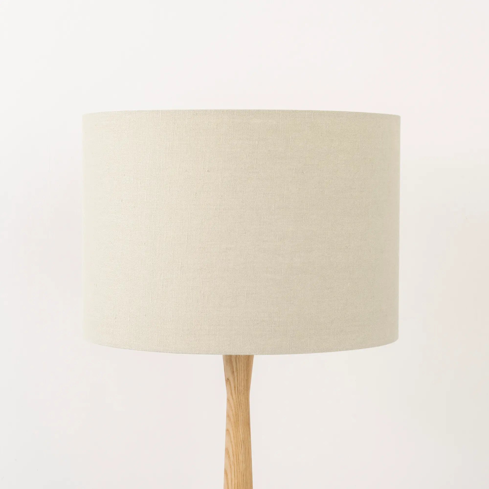 Oatmeal lampshade made from textured linen on wooden stand