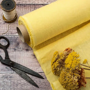 Pale Yellow linen fabric, ready to cut, with scissors, thread bobbins and flowers