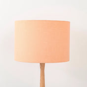 Peach lampshade made from textured linen on wooden stand