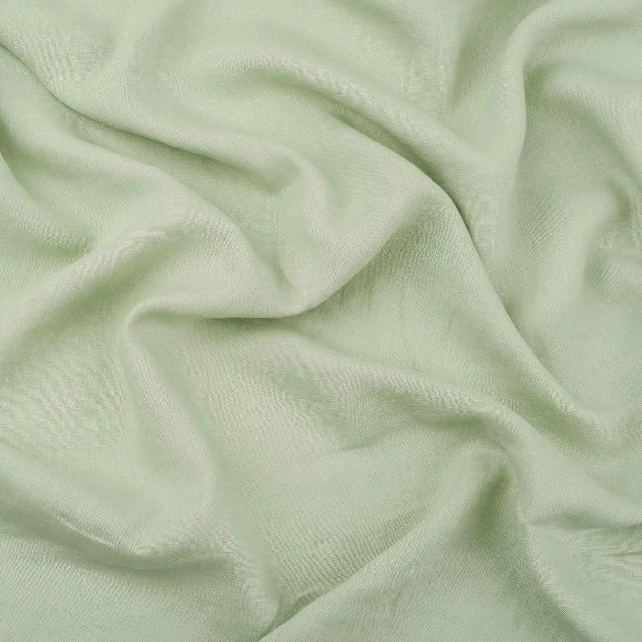 Pistachio Green linen fabric, crumpled to show its natural texture, washed European flax