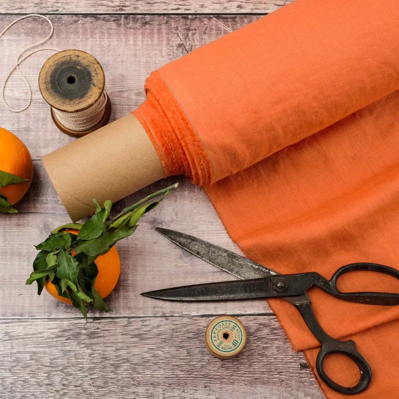 Tangerine linen fabric, ready to cut, with scissors, thread bobbins and flowers