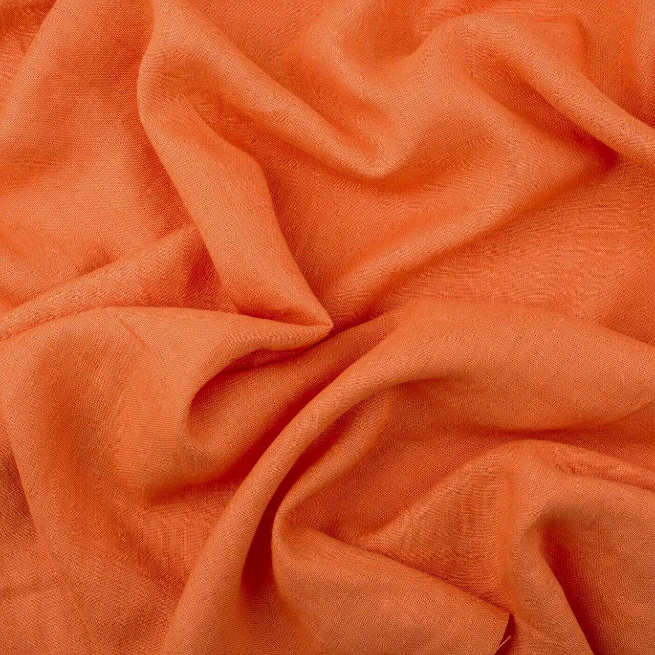 Tangerine linen fabric, crumpled to show its natural texture, washed European flax