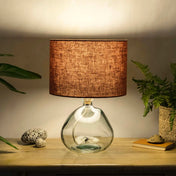 Terracotta lampshade made from textured linen illuminated on recycled glass table lamp