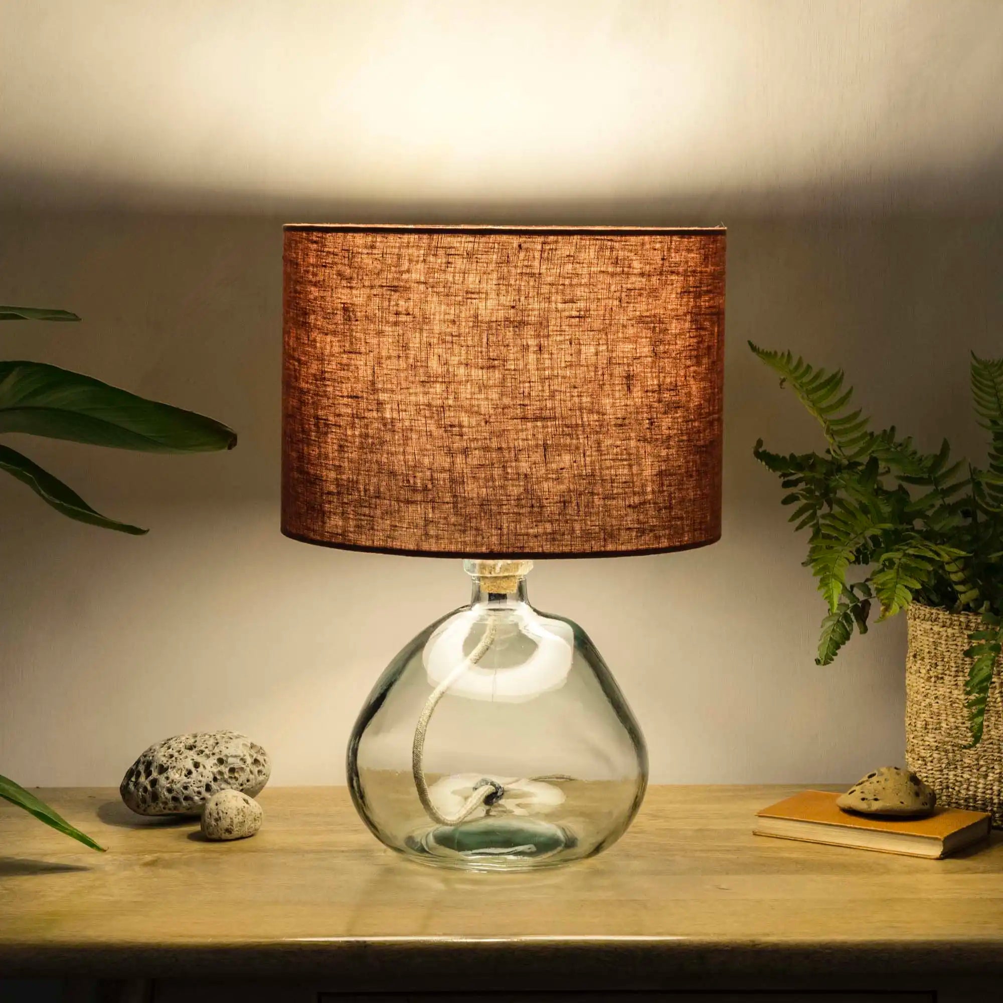 Terracotta lampshade made from textured linen illuminated on recycled glass table lamp