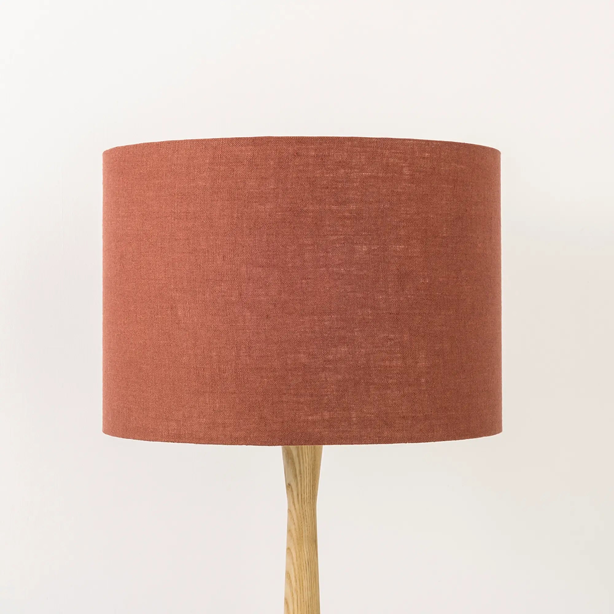 Terracotta lampshade made from textured linen on wooden stand