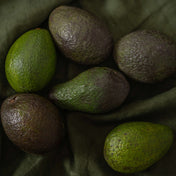 Avocados on green linen fabric