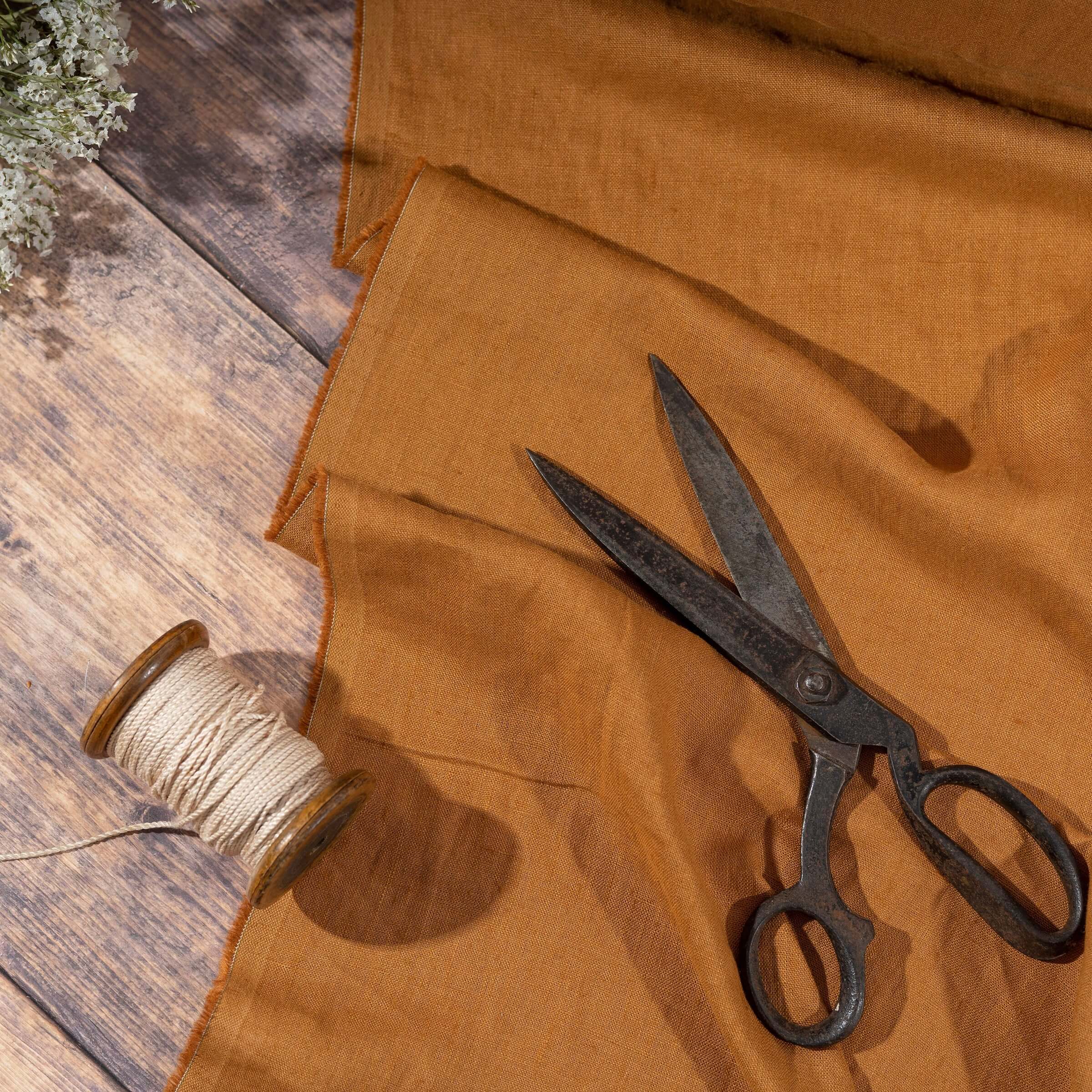 Rust Brown linen fabric, ready to cut, with scissors, thread bobbins and flowers