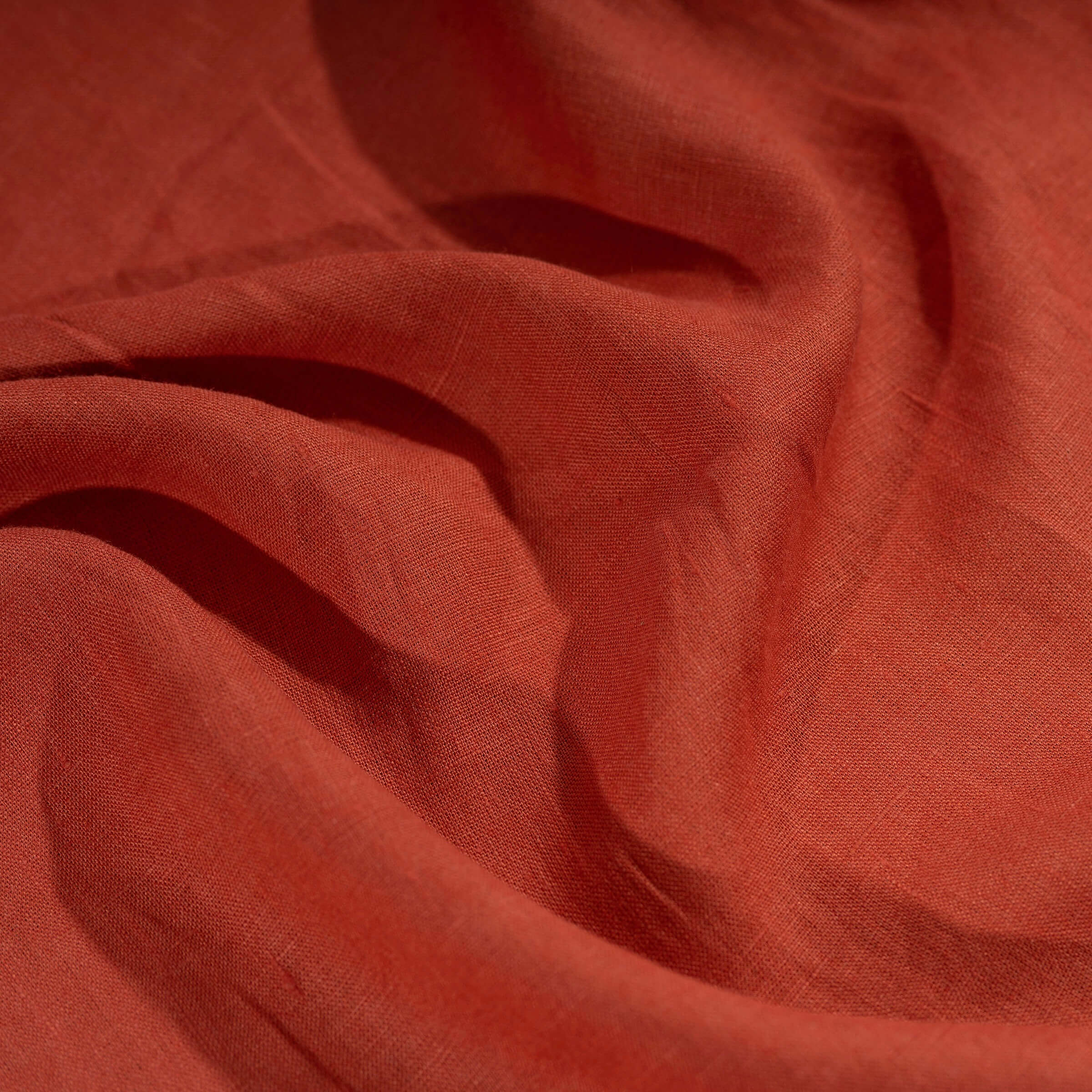 Brick Red linen fabric, crumpled to show its natural texture, washed European flax