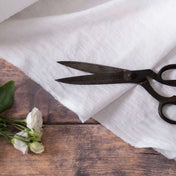 Bright White linen fabric, ready to cut, with scissors, thread bobbins and flowers