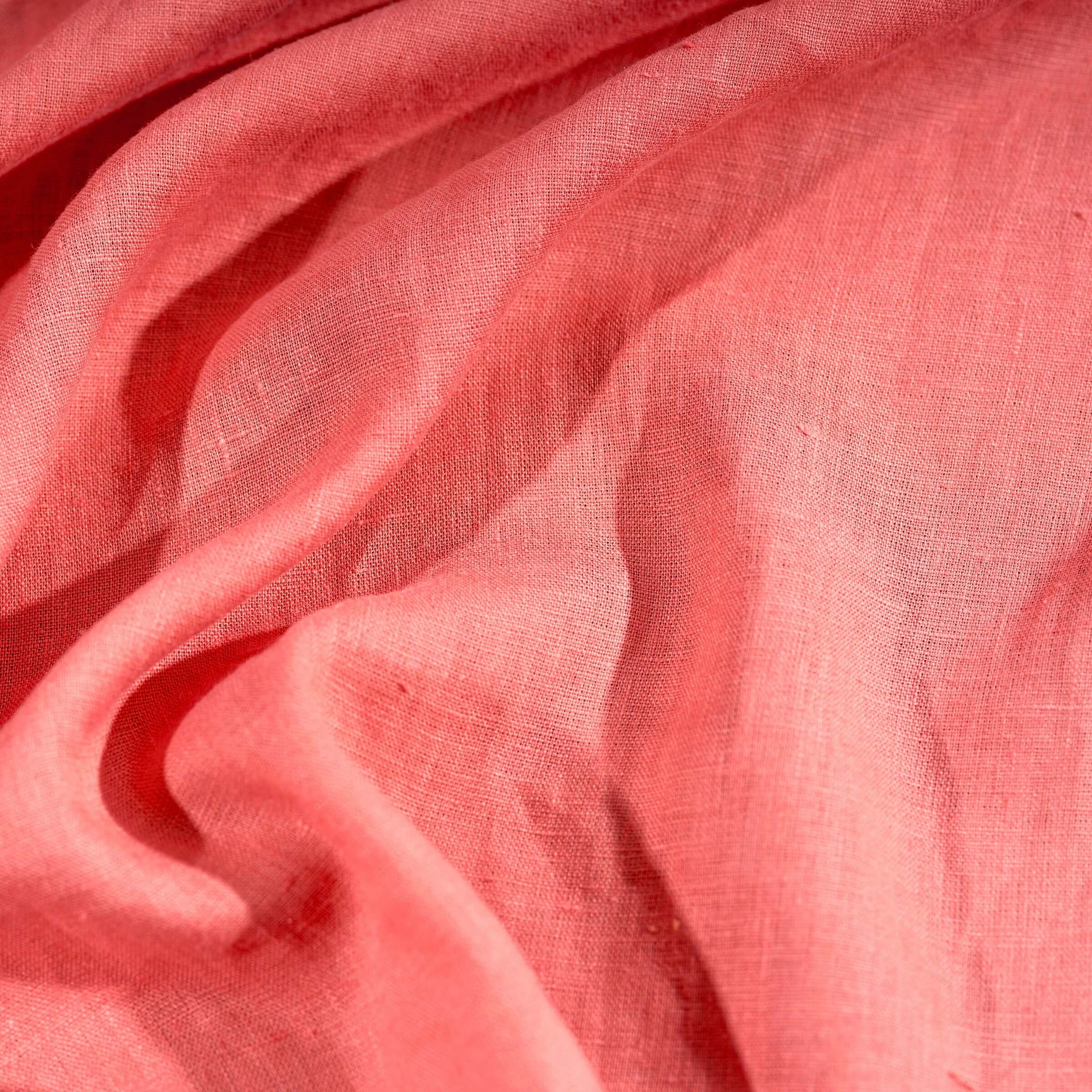 Coral Pink linen fabric, crumpled to show its natural texture, washed European flax