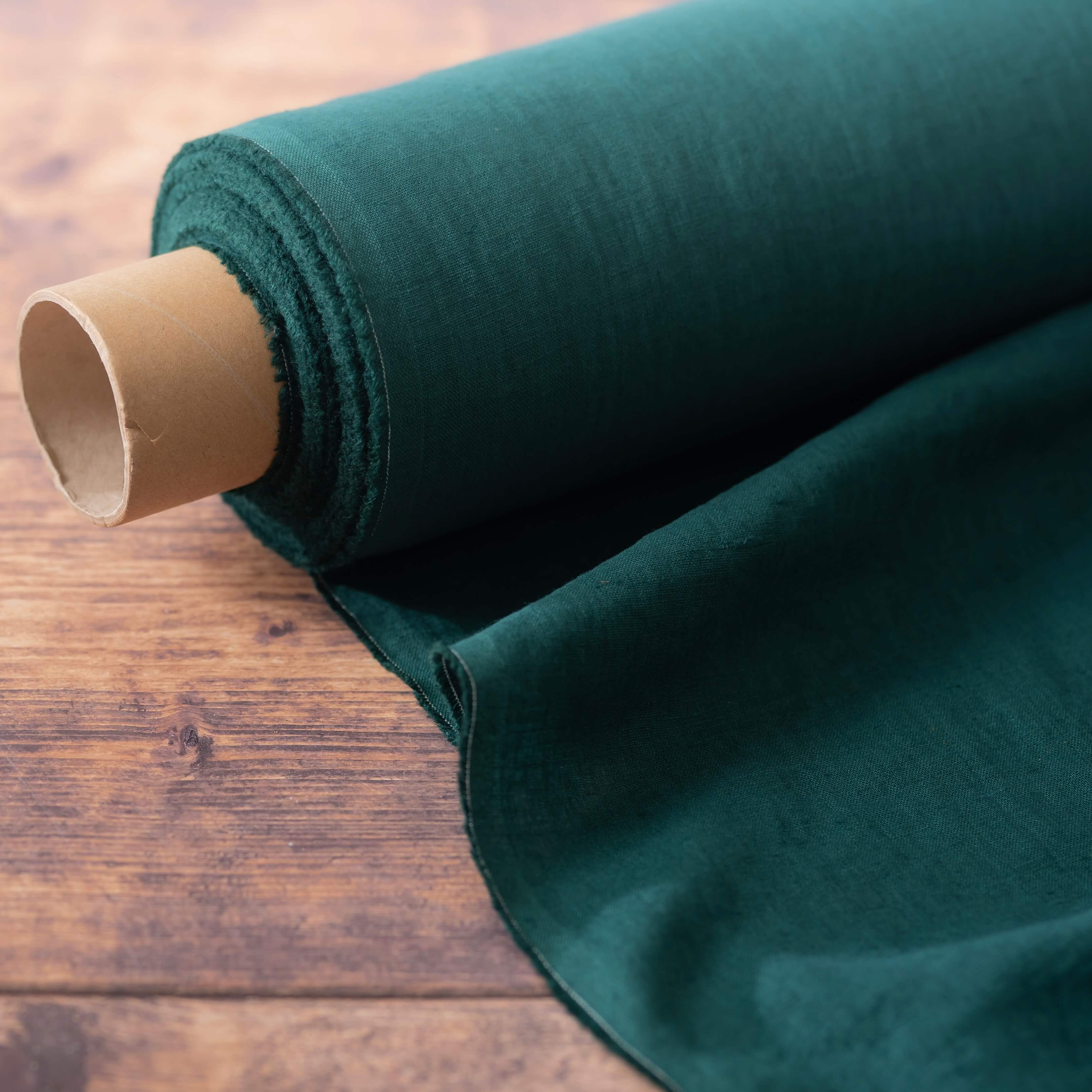 Dark Forest Green linen fabric, ready to cut, with scissors, thread bobbins and flowers