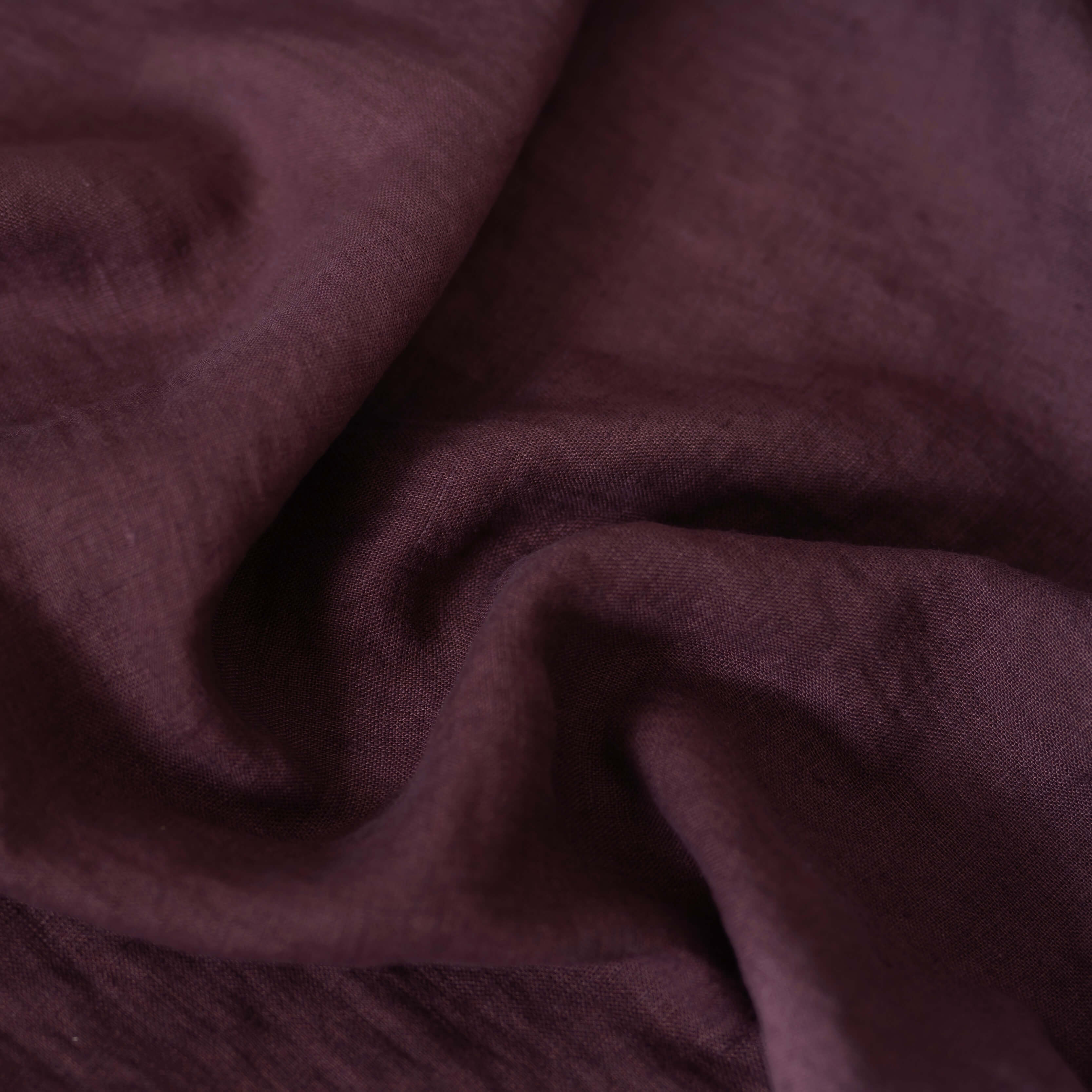 Dark Plum Purple linen fabric, crumpled to show its natural texture, washed European flax