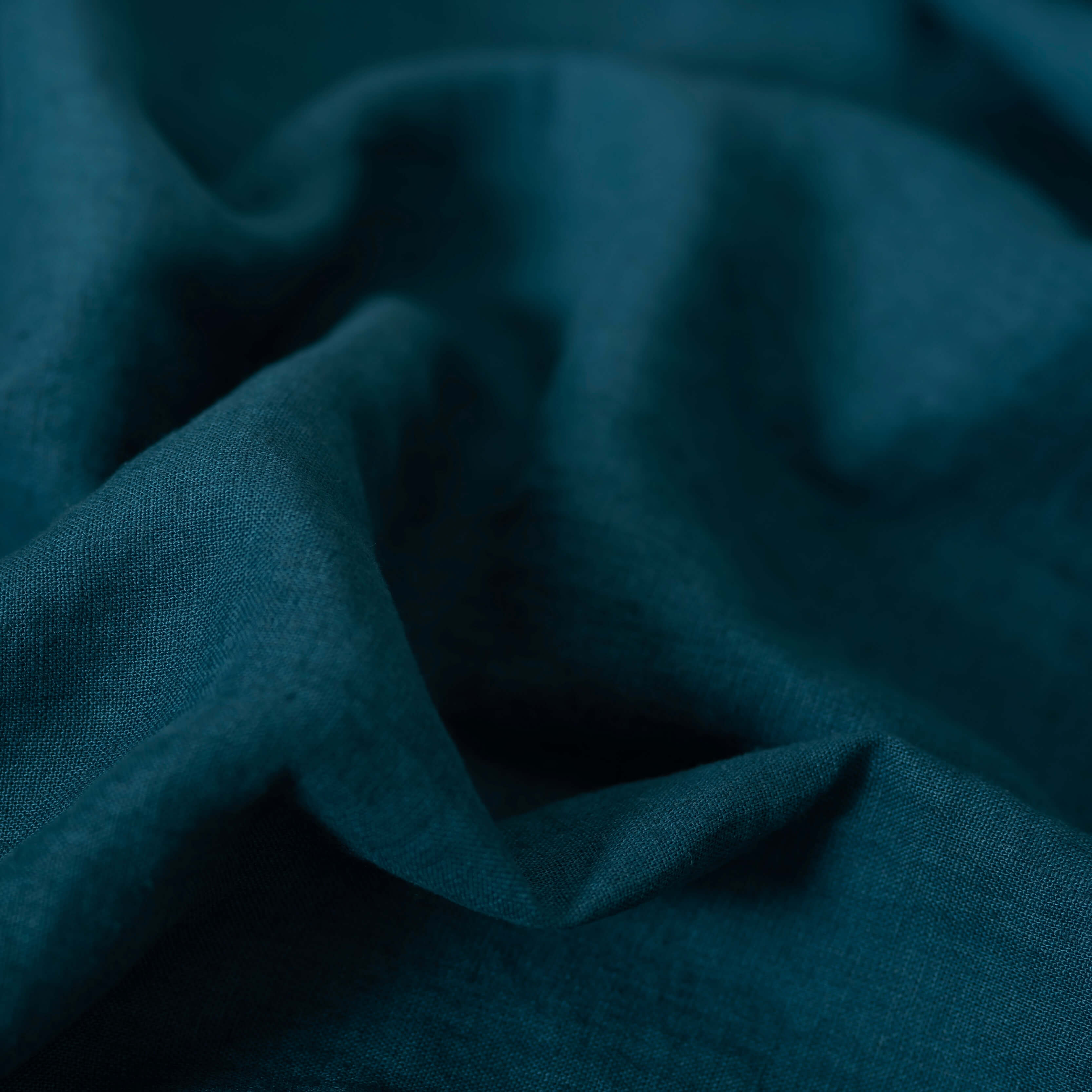Deep Teal linen fabric, crumpled to show its natural texture, washed European flax