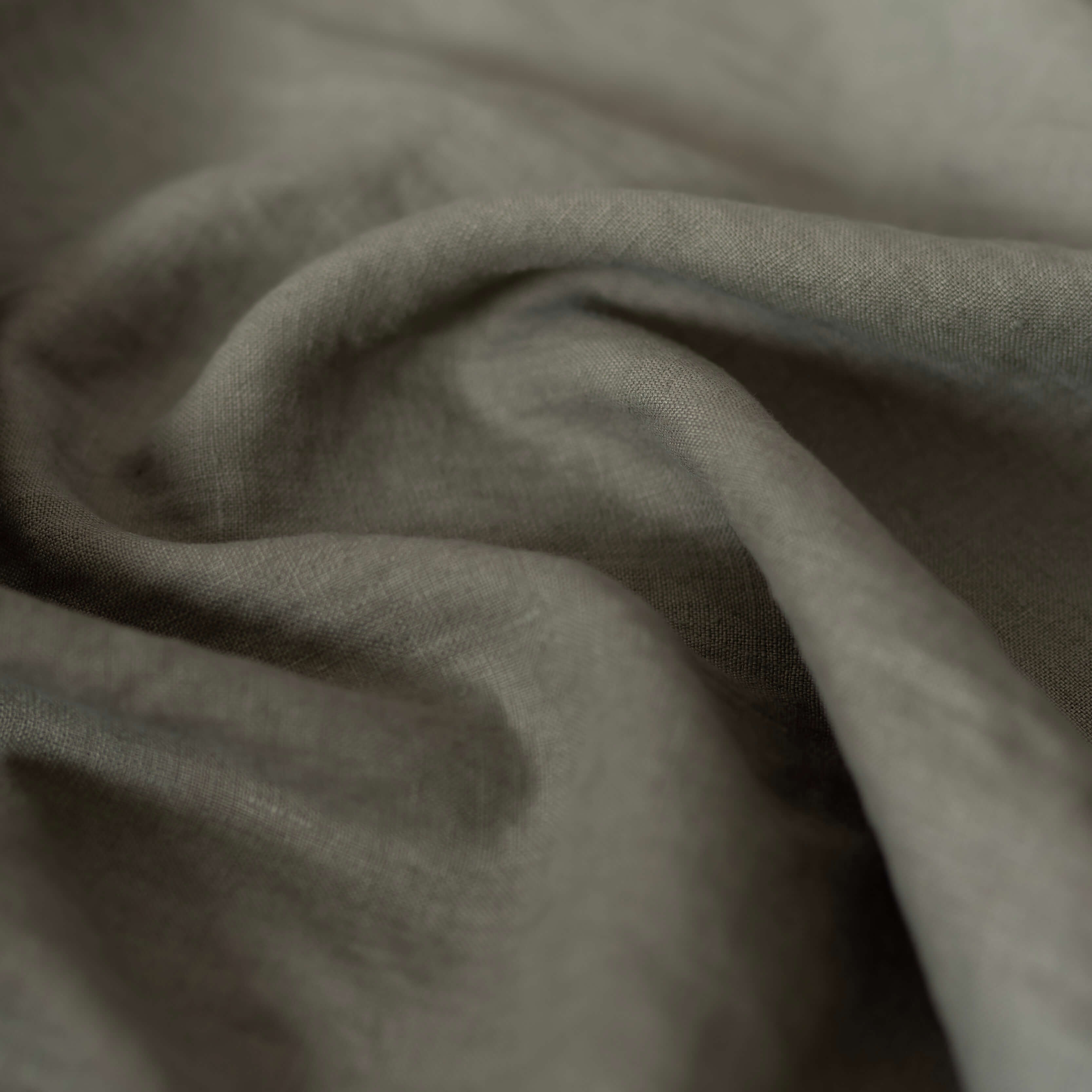 Dusty Sage Green linen fabric, crumpled to show its natural texture, washed European flax