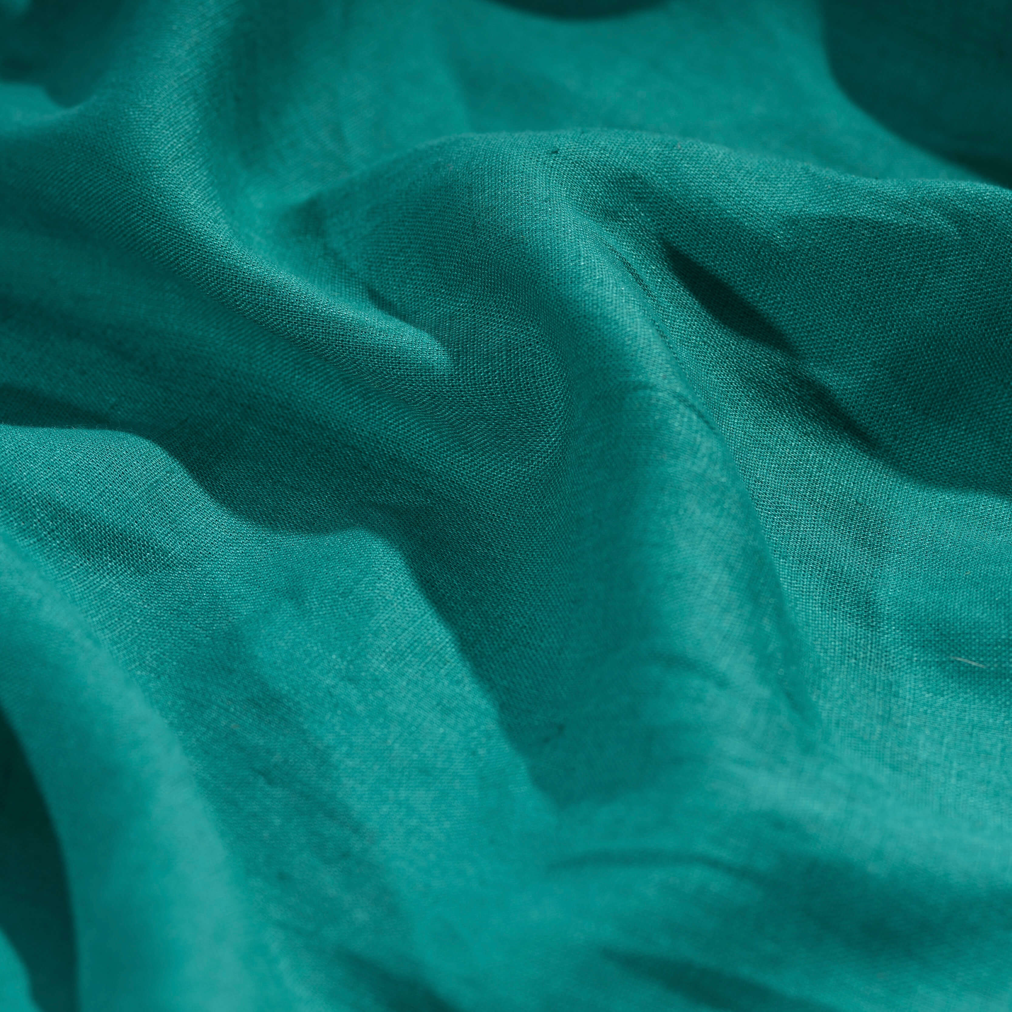 Emerald Green linen fabric, crumpled to show its natural texture, washed European flax