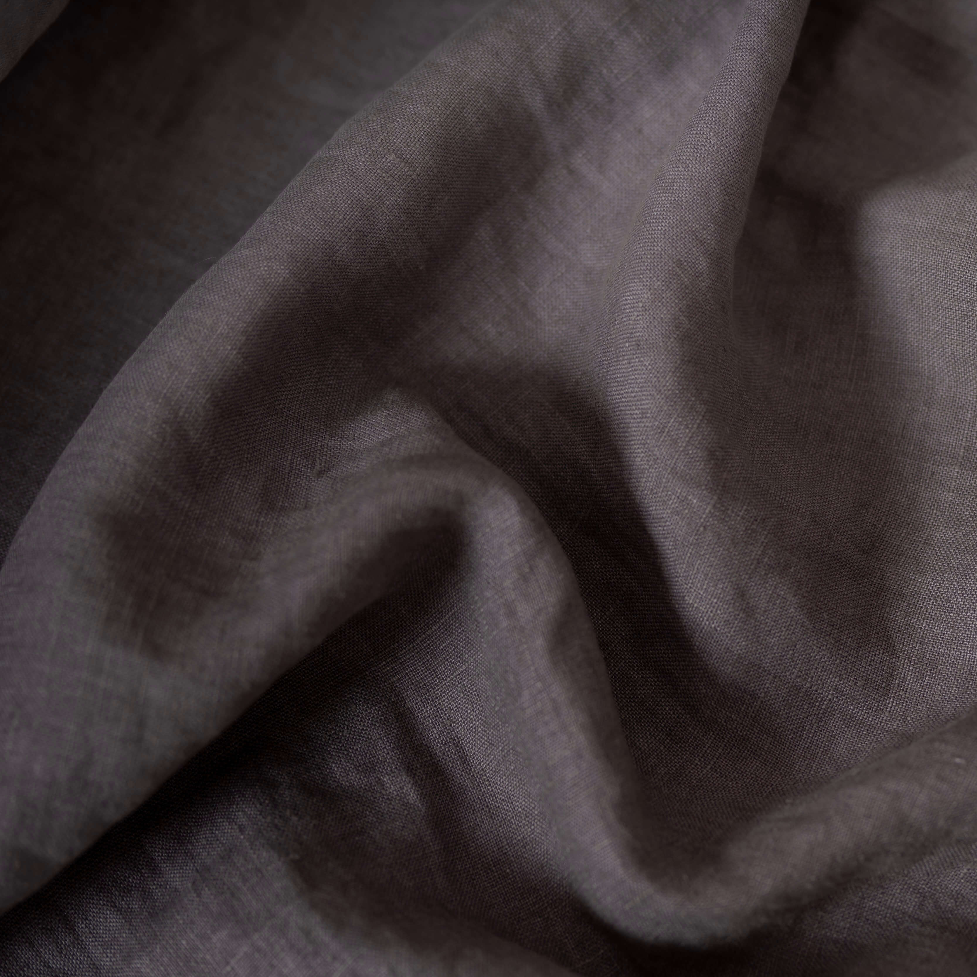 Graphite Grey linen fabric, crumpled to show its natural texture, washed European flax