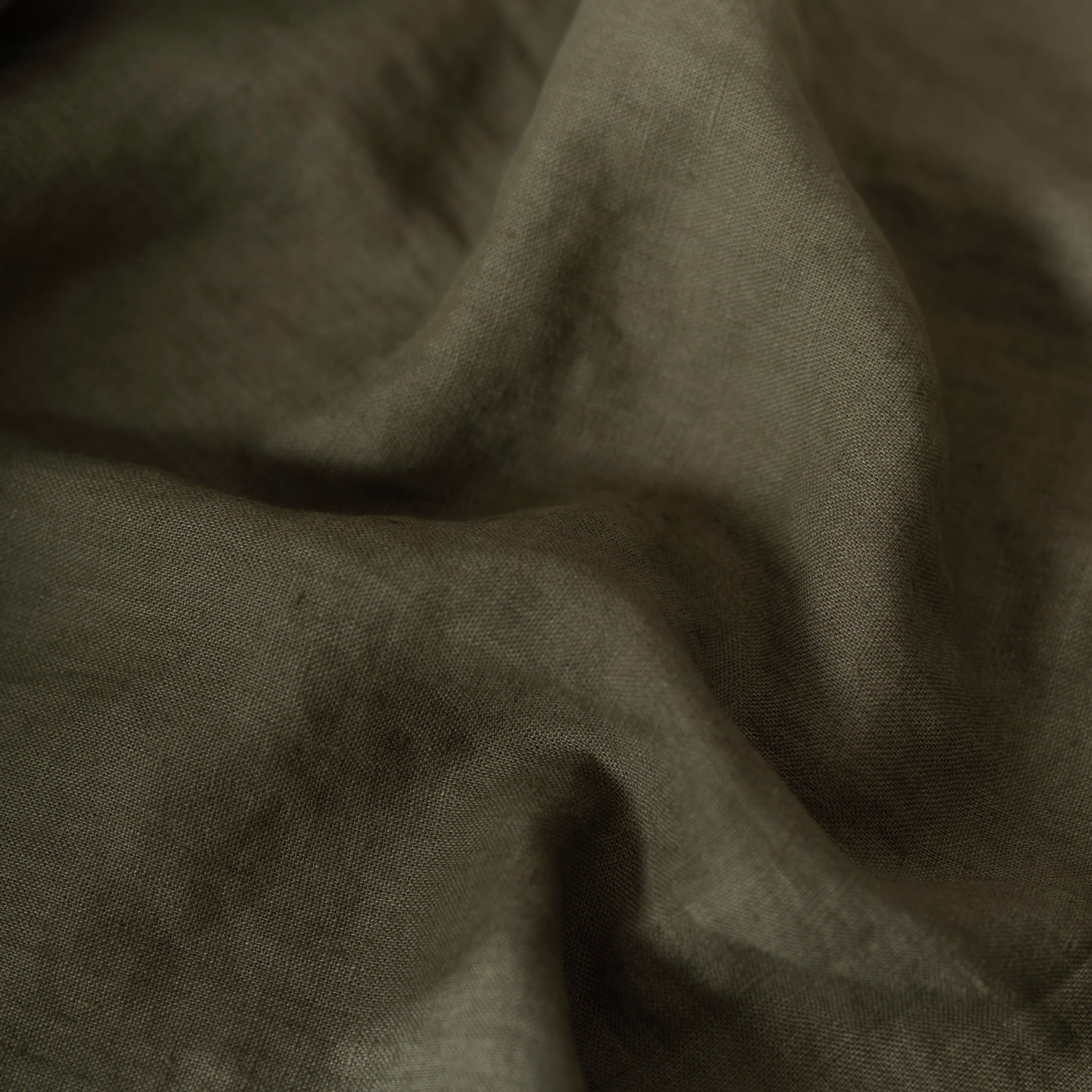 Khaki Green linen fabric, crumpled to show its natural texture, washed European flax