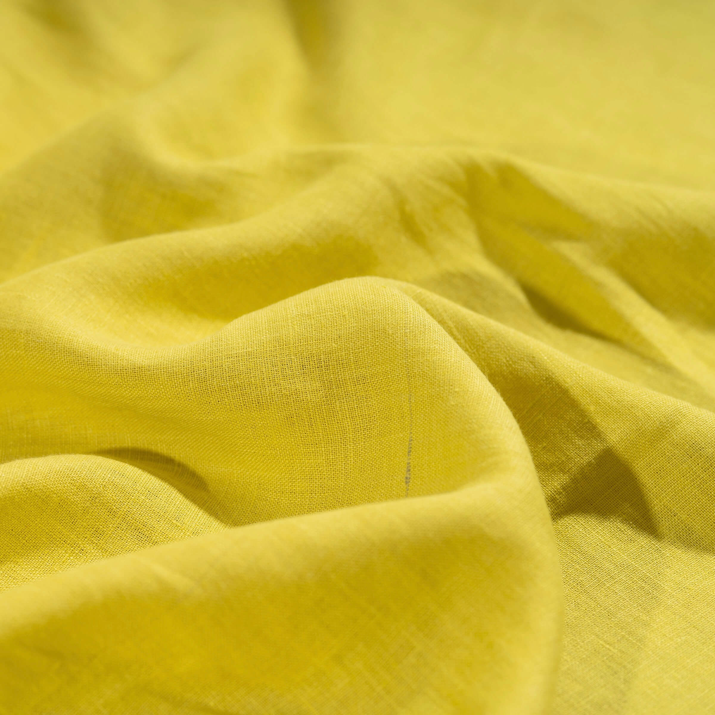 Lemon linen fabric, crumpled to show its natural texture, washed European flax