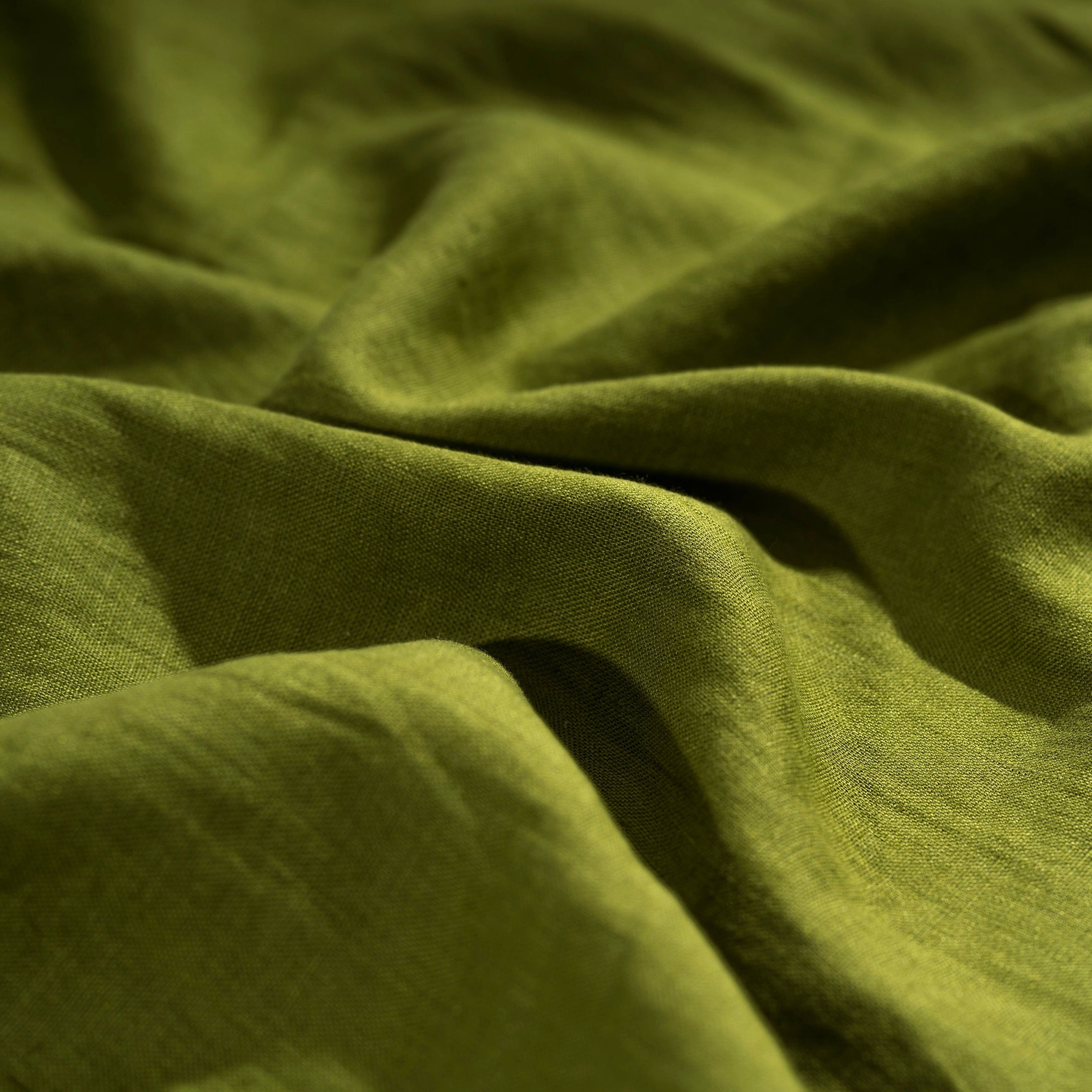 Moss Green linen fabric, crumpled to show its natural texture, washed European flax