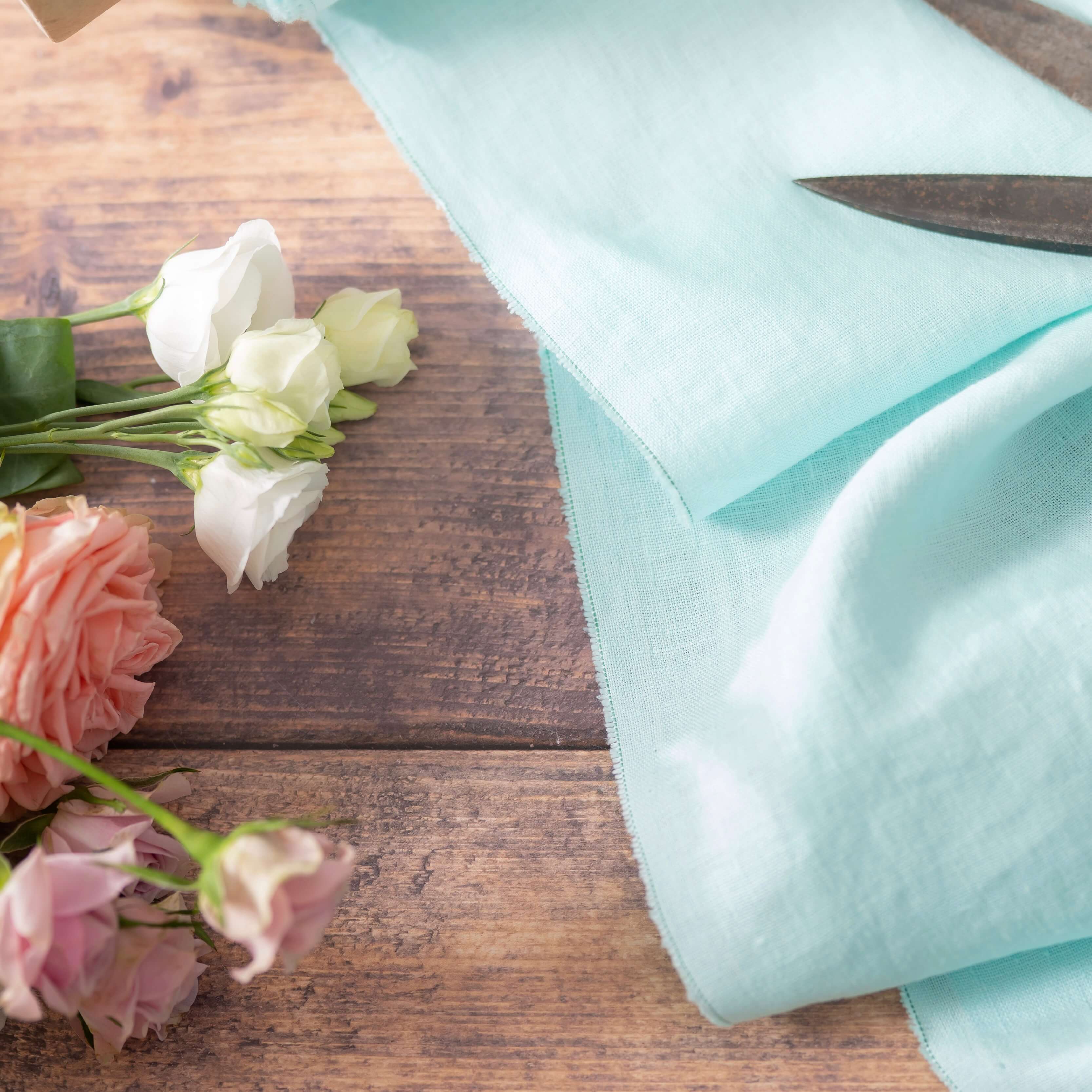 Pastel Light Mint linen fabric, ready to cut, with scissors and flowers