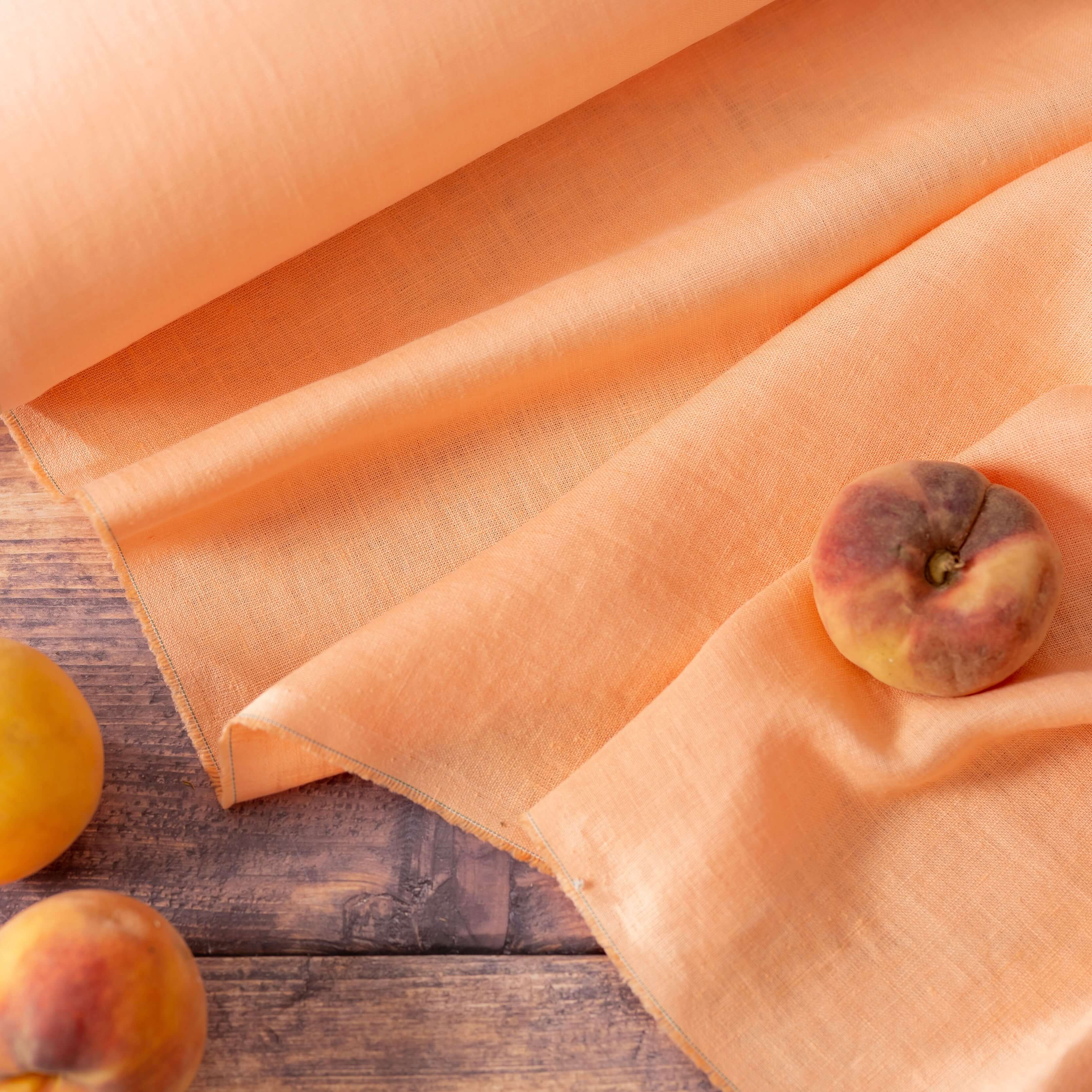 Peach linen fabric, flat lay showing its natural weave, washed European flax