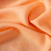 Peach linen fabric, crumpled to show its natural texture, washed European flax