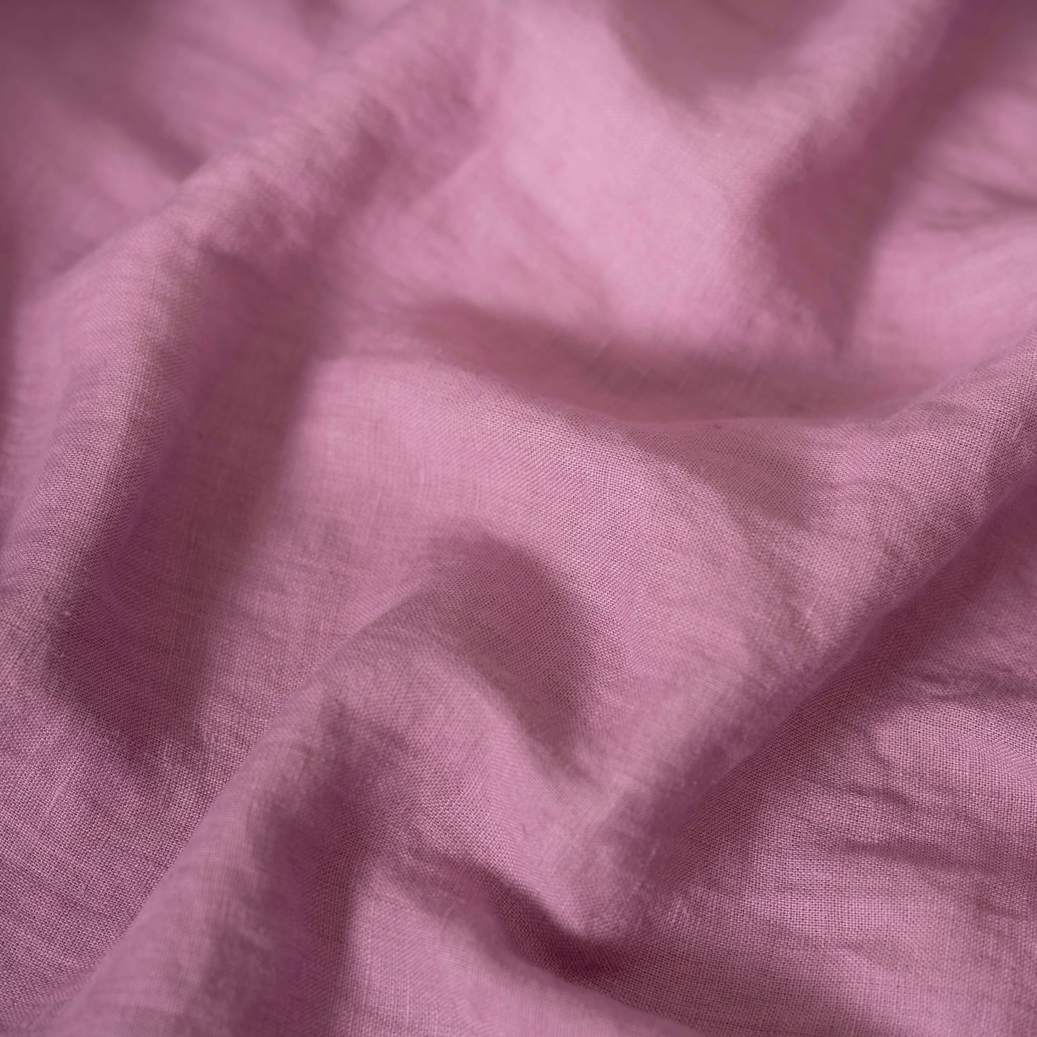 Pink Lilac linen fabric, crumpled to show its natural texture, washed European flax