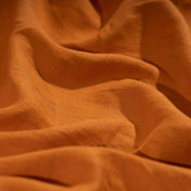 Pumpkin Orange linen fabric, crumpled to show its natural texture, washed European flax