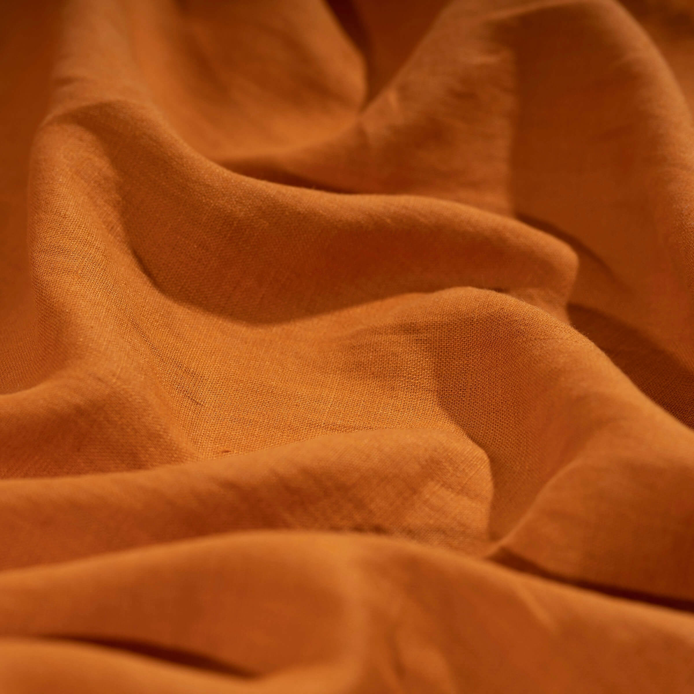 Pumpkin Orange linen fabric, crumpled to show its natural texture, washed European flax