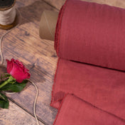 Raspberry linen fabric, ready to cut, with scissors, thread bobbins and flowers