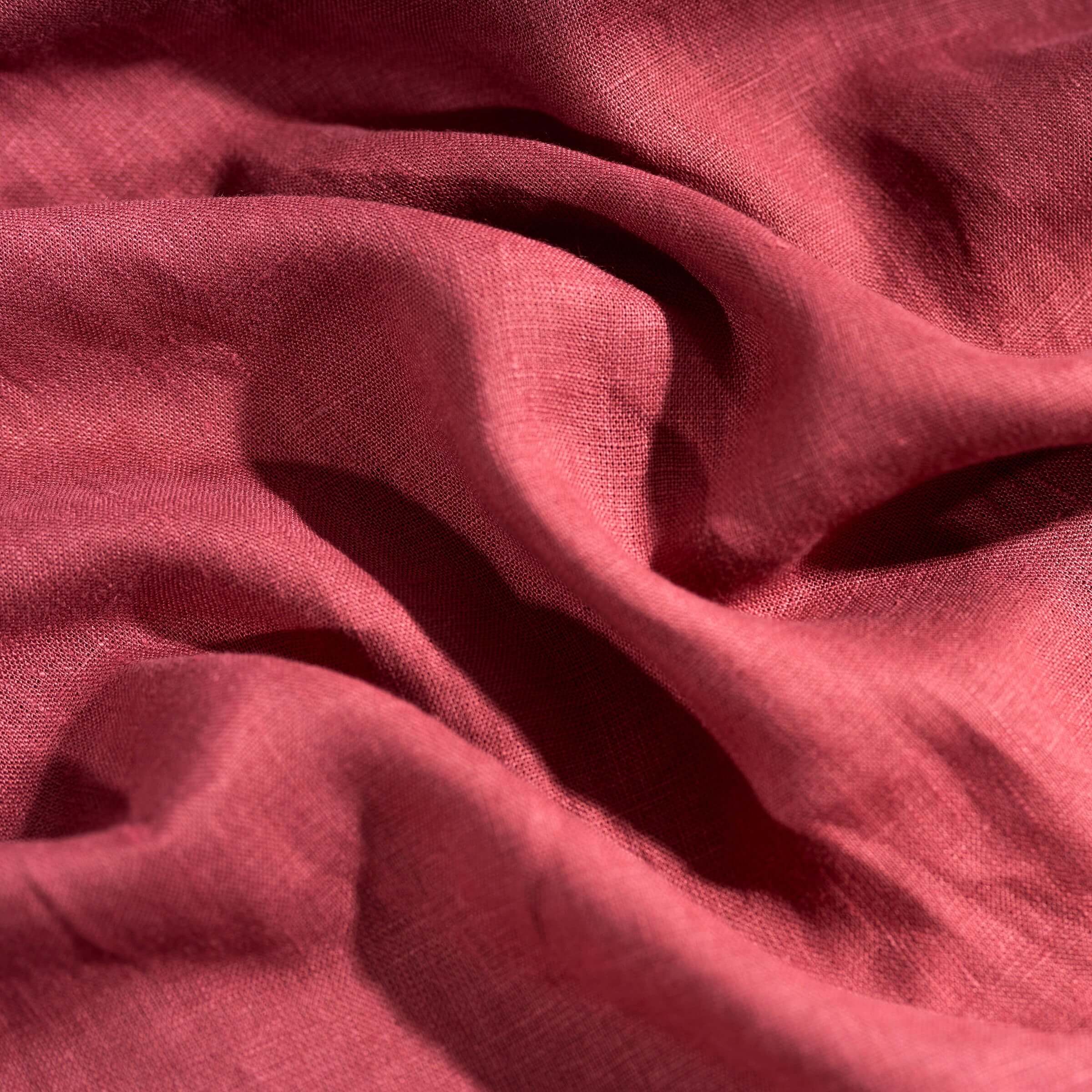 Raspberry linen fabric, crumpled to show its natural texture, washed European flax