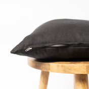 Black linen cushion cover with zipper on wooden table
