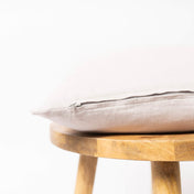 Coconut milk linen cushion cover with zipper closure on wooden stool