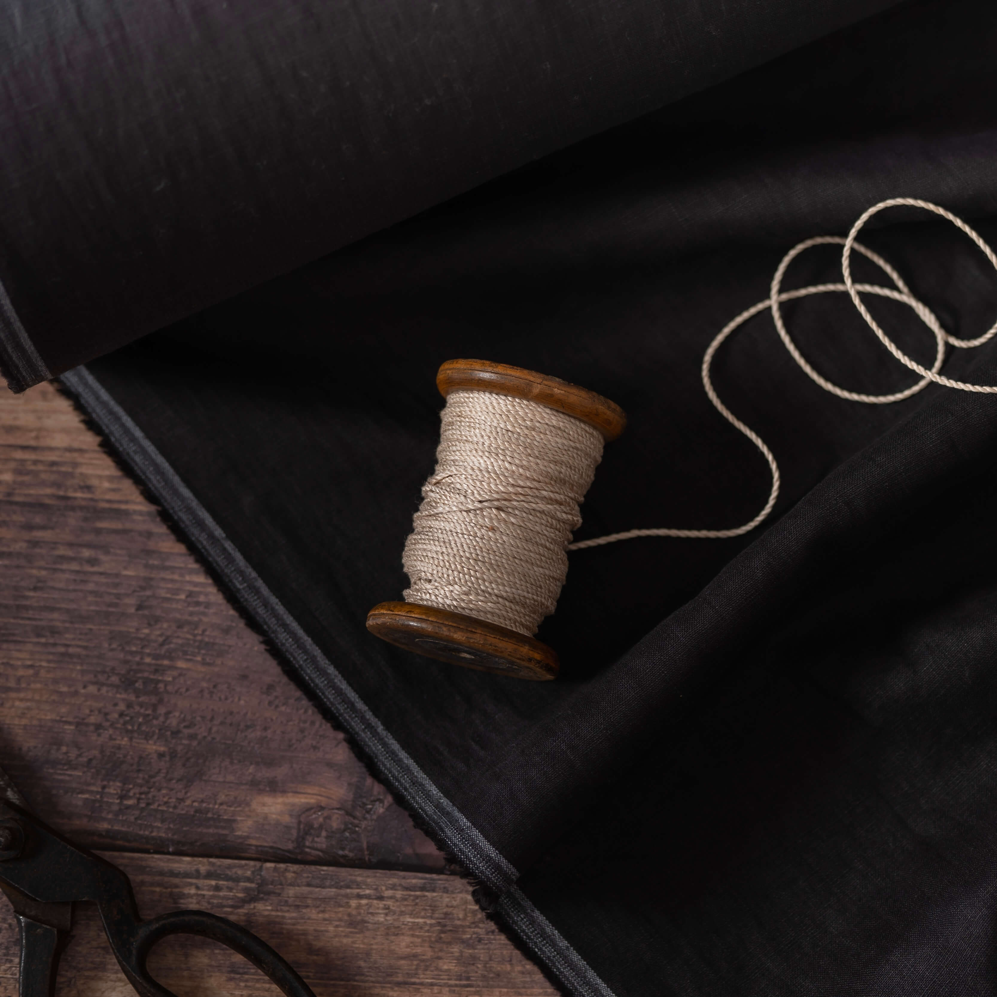 Bobbin on black linen fabric