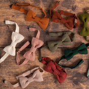 Collection of colourful linen bow ties on wooden table